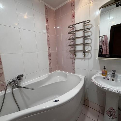a white bath tub in a bathroom with a sink at Two bedroom in Park Zone in Kamianets-Podilskyi