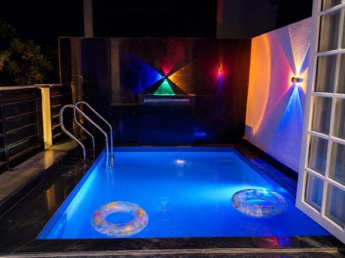 a swimming pool with blue lighting in a house at night at Vista Royal 2BHK With Private Pool in Igatpuri