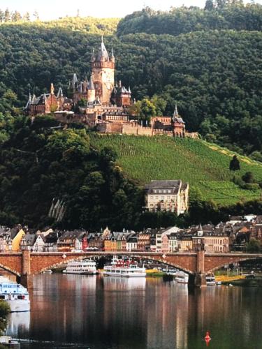 a castle on top of a hill next to a river at Stadtblick in Cochem