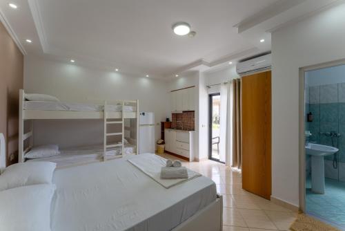 a bedroom with two bunk beds and a bathroom at Poseidon Family Hotel Ksamil in Ksamil