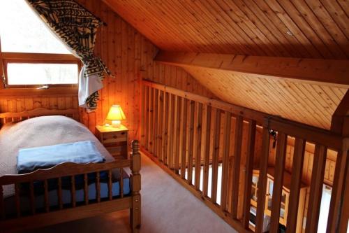 a bedroom with a bed in a wooden cabin at Chalet Thiennet in Mesples