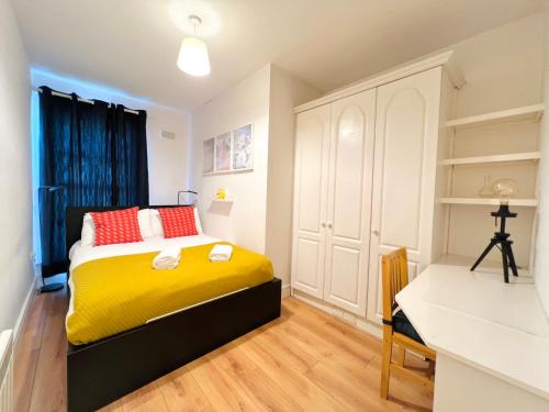 a bedroom with a yellow bed and a desk at One Bedroom Central Site Apartment in Dublin