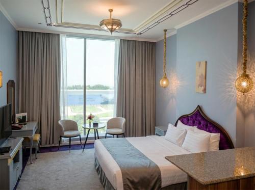 a hotel room with a bed and a large window at Saraya Corniche Hotel in Doha