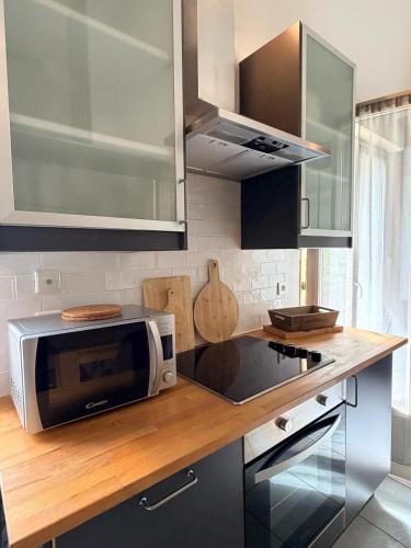 a kitchen with a microwave on a wooden counter top at La Petite Maison in Montbard