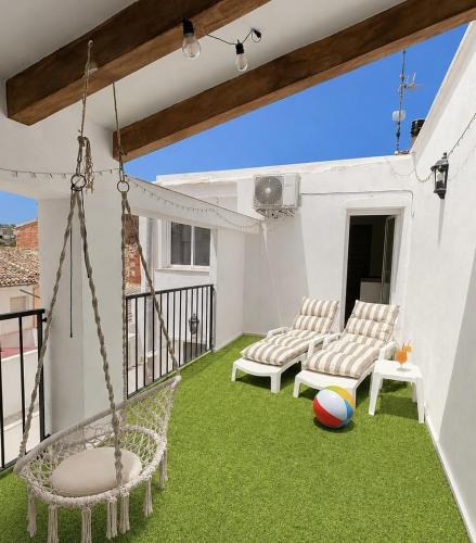 a patio with a swing and a ball on the grass at Casa Vicen in Bolbaite