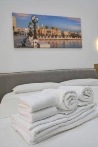 a pile of towels sitting on top of a bed at Adriatic Breeze Rooms in Mola di Bari