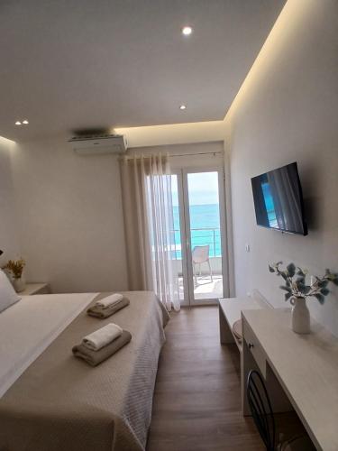 a bedroom with a bed and a television and a balcony at NaDim rooms in Himare