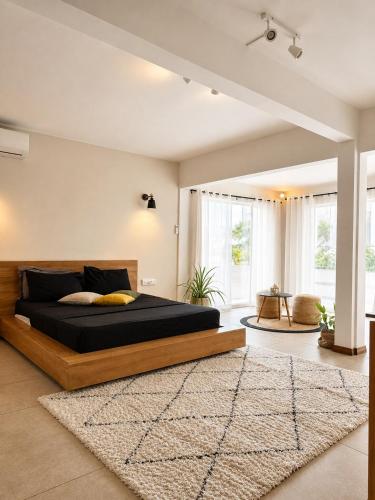 a bedroom with a large bed and a rug at Villa Ptit Bouchon - En face de la Plage - Facing beach with Ocean views in Bouchon