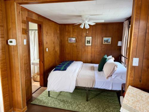 a bedroom with a bed and a ceiling fan at Highland House and Cottages in Carroll