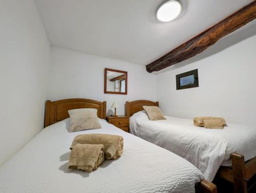 two twin beds in a room with white walls at Casas Telhadas in Trancoso