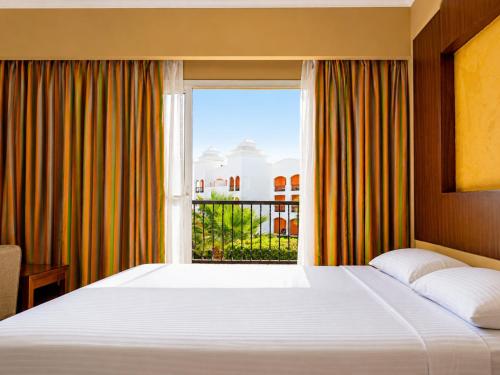 a bedroom with a large bed and a window at Fun & Sun Naama Waves in Sharm El Sheikh
