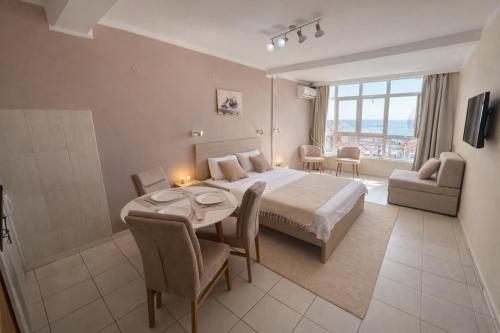 a bedroom with a bed and a table and chairs at Sea View Apartment Rafailovići in Rafailovici
