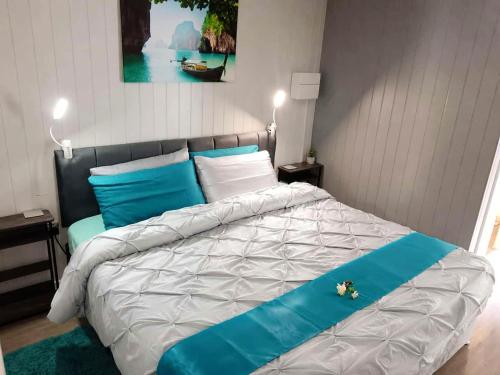a bedroom with a large bed with blue and white pillows at Garden Guesthouse, Sleep4, Private Entrance, Parking, Wifi, AirCon, Derby City in Derby