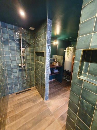 a bathroom with a shower with green tiles on the wall at Surf & Sauna Bud House in Longeville-sur-Mer