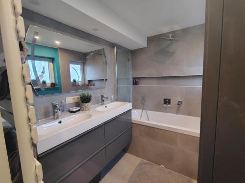 a bathroom with two sinks and a bath tub at La clé des champs chambre d'hôtes in Theux