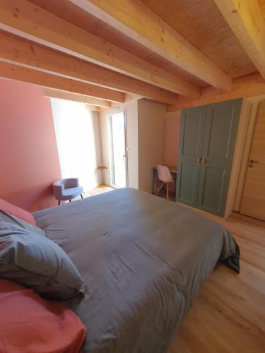a bedroom with a large bed in a room with wooden ceilings at Surf & Sauna Bud House in Longeville-sur-Mer