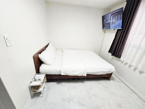 a bedroom with a bed with a tv on the wall at AnJin's Guest House in Mokpo