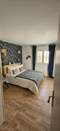a bedroom with a large bed with blue curtains at Charmante et Chaleureuse petite maison in Châteauneuf-du-Pape
