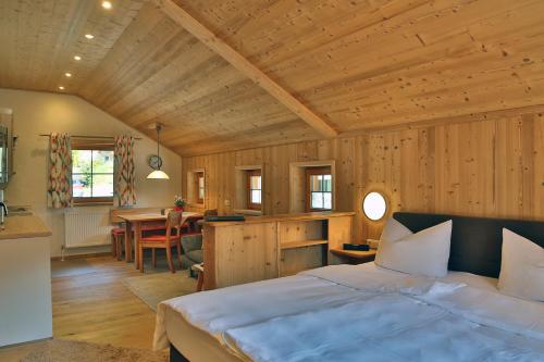 a bedroom with a bed and a kitchen and a table at Pension Monteneu in Bartholomäberg