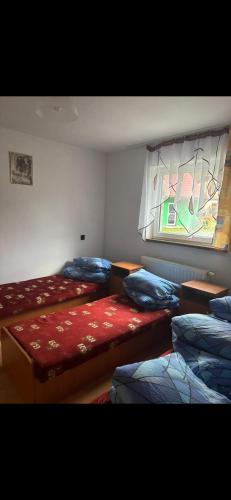 a room with three beds and a window at Pokoje u podnóży Karkonoszy in Borowice