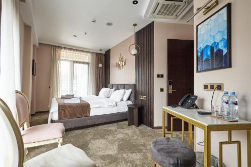 a hotel room with a bed and a desk with a phone at Panorama Boutique Hotel in Tbilisi City