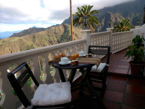 a table and chairs on a balcony with a view at Casa La Bodega in Hermigua