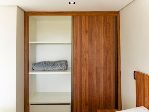 a bedroom with a book shelf and a wooden door at Loft Alegria in Avaré