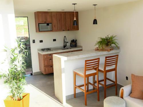 a kitchen with a counter and two chairs and a counter top at Loft Alegria in Avaré