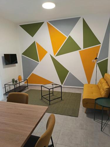 a room with a colorful wall with a couch and tables at Casa RAFFAELLO in Vigevano