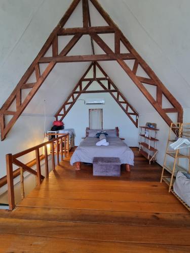a bedroom with a bed in a attic at Valhalla Mentawai in Katiet