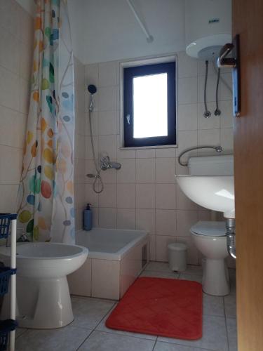 a bathroom with a tub and a sink and a toilet at LadyBird and Turtle in Podglavica