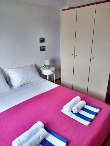a bedroom with a bed with towels on a pink blanket at LadyBird and Turtle in Podglavica