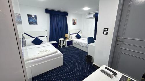 a hotel room with two beds and a door at Istanbul HOTEL Minya in Minya