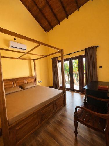 a bedroom with a canopy bed and a desk at CocoBaru - Private Beachfront Entire Villa in Marawila