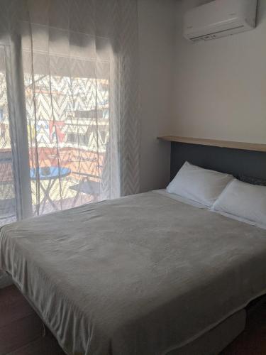 a bedroom with a large bed with a window at Aquamarine Centrale in Kavála