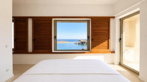 a bedroom with a window with a view of the ocean at Kohili Private Villa in Karistos