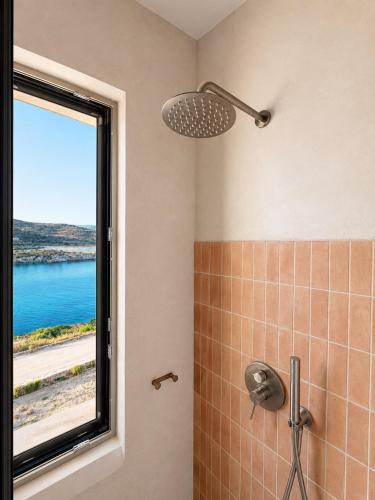 a bathroom with a shower with a window at Kohili Private Villa in Karistos