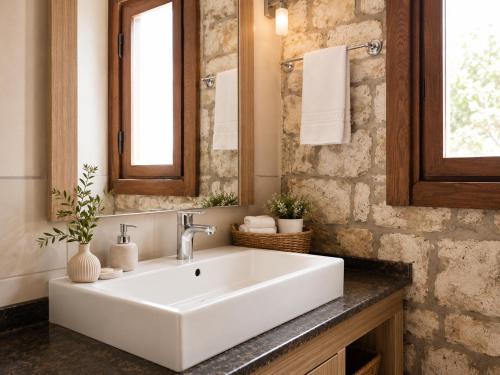 ein Badezimmer mit einem weißen Waschbecken und einem Spiegel in der Unterkunft D'core Alacati in Cesme