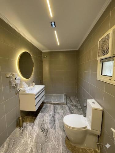 a bathroom with a toilet and a sink and a mirror at Le caire Hotel & suits in Cairo
