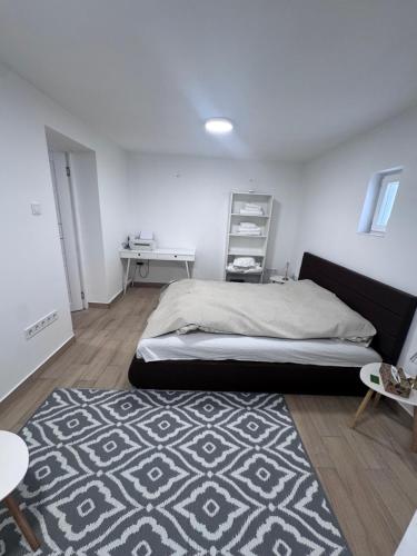 a bedroom with a large bed and a rug at Fresh Time Apartment in Kecskemét