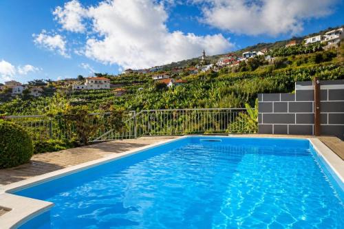 a swimming pool with a hill in the background at Bluegreen in Arco da Calheta