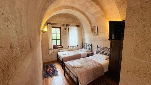 a room with two beds and a tv in it at Nature Park Cave Hotel in Göreme