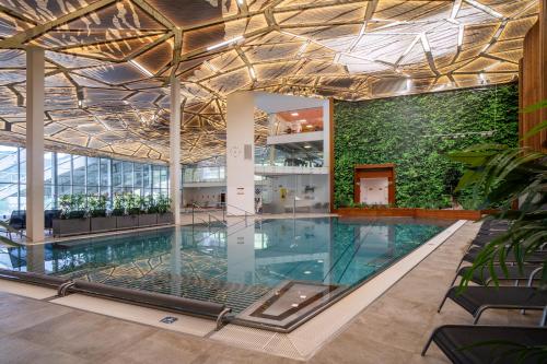 a pool in a building with a green wall at Rezort Gothal Chalupy in Donovaly