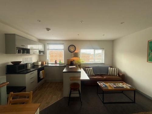a kitchen and living room with a couch and a table at The Crows Nest - Sheringham in Sheringham