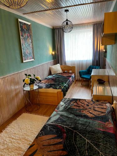 a hotel room with two beds and a couch at Rózsa nyaralóház in Balatonboglár