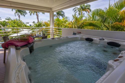 a hot tub on the balcony of a house at Majesty Palm Hôtel in Saint-François