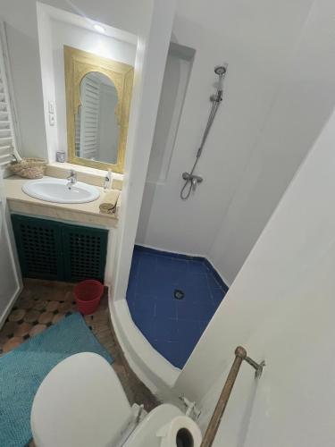 a bathroom with a sink and a toilet and a mirror at Riad darkoum in Essaouira