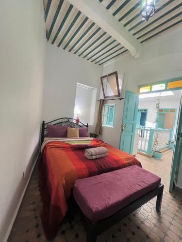 a bedroom with a large bed with a red blanket at Riad darkoum in Essaouira