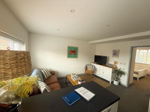 a living room with a couch and a table at The Crows Nest - Sheringham in Sheringham