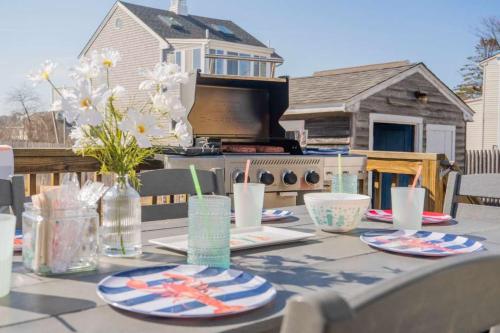 a table with plates and flowers on a patio at Mimi's Beach House Beach Access in Wells